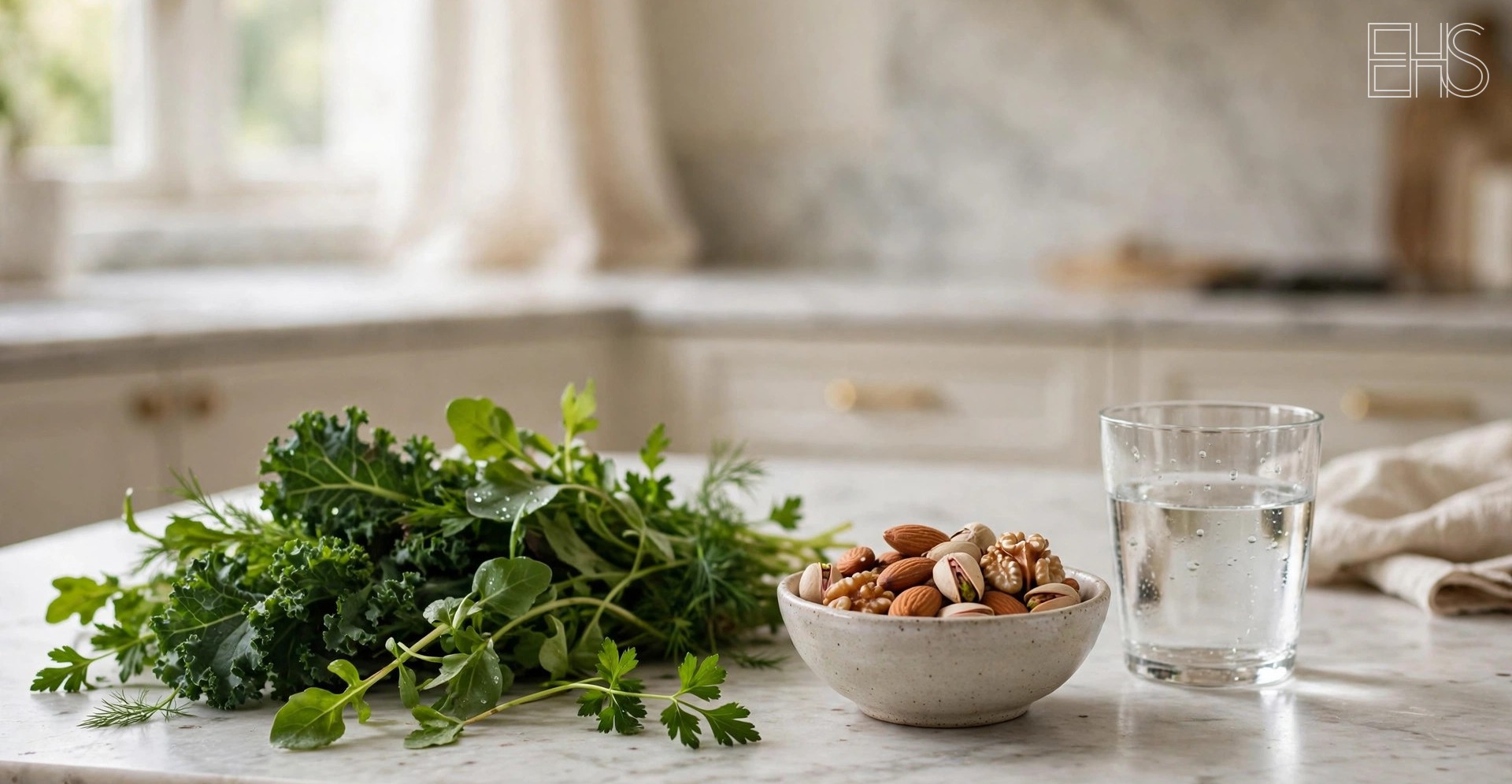 EverHealthSpan editorial photo: a marble kitchen counter with fresh leafy greens, a ceramic bowl of mixed nuts, and a glass of water.